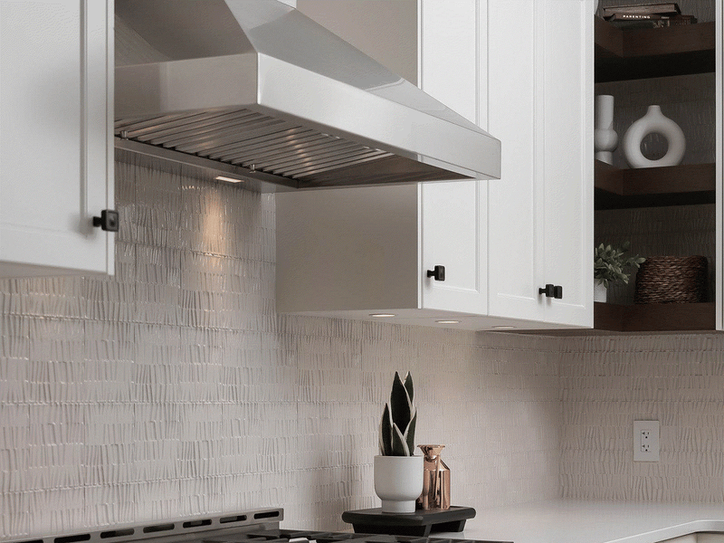 Victory Twister 36 Inch Wall Mount Range Hood installed in a white kitchen with stainless steel baffle filters and LED lighting