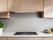 A professional installation of the Victory Q6 showing a flush mount fit inside custom kitchen cabinetry above a cooktop